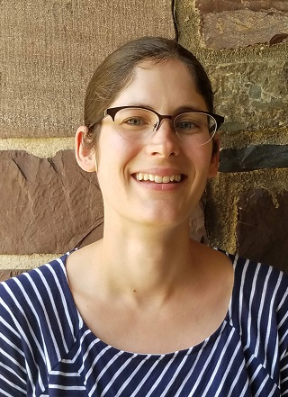 headshot of a woman wearing a navy blue and white striped blouse